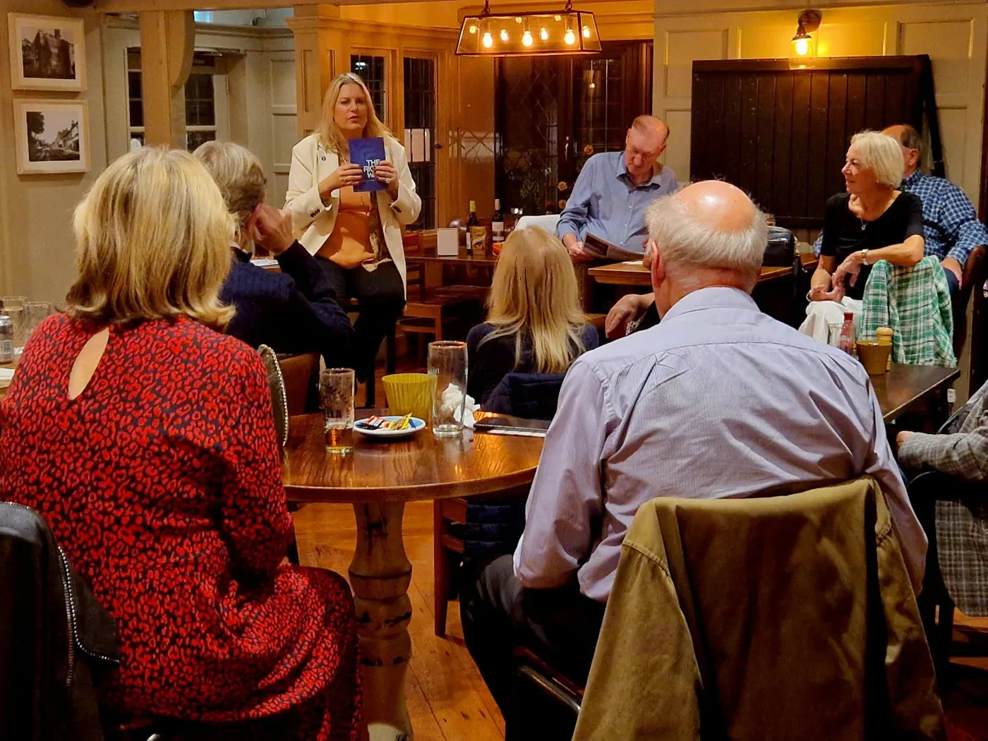 Mims Davies MP holding a copy of The Right Way as she talks to residents at the Highlands Inn in Uckfield
